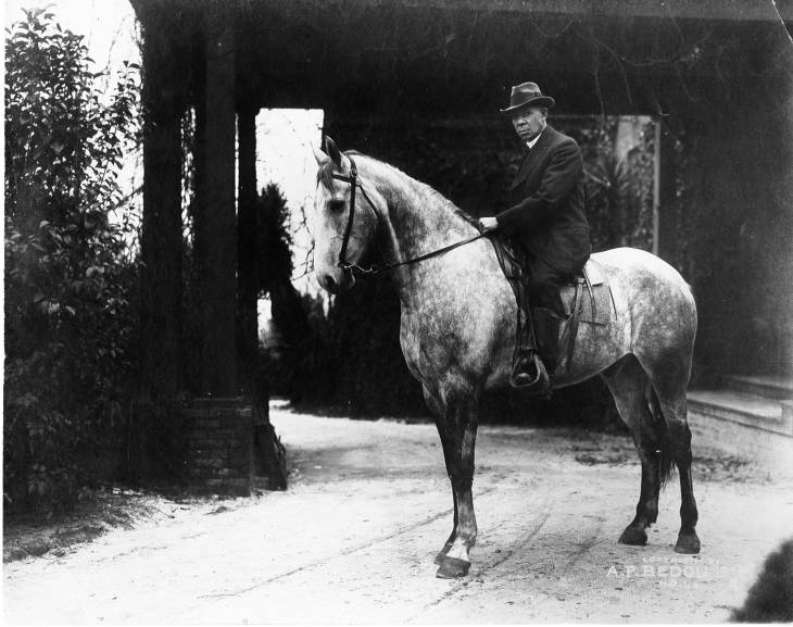 Booker T. Washington riding a flea bitten grey horse